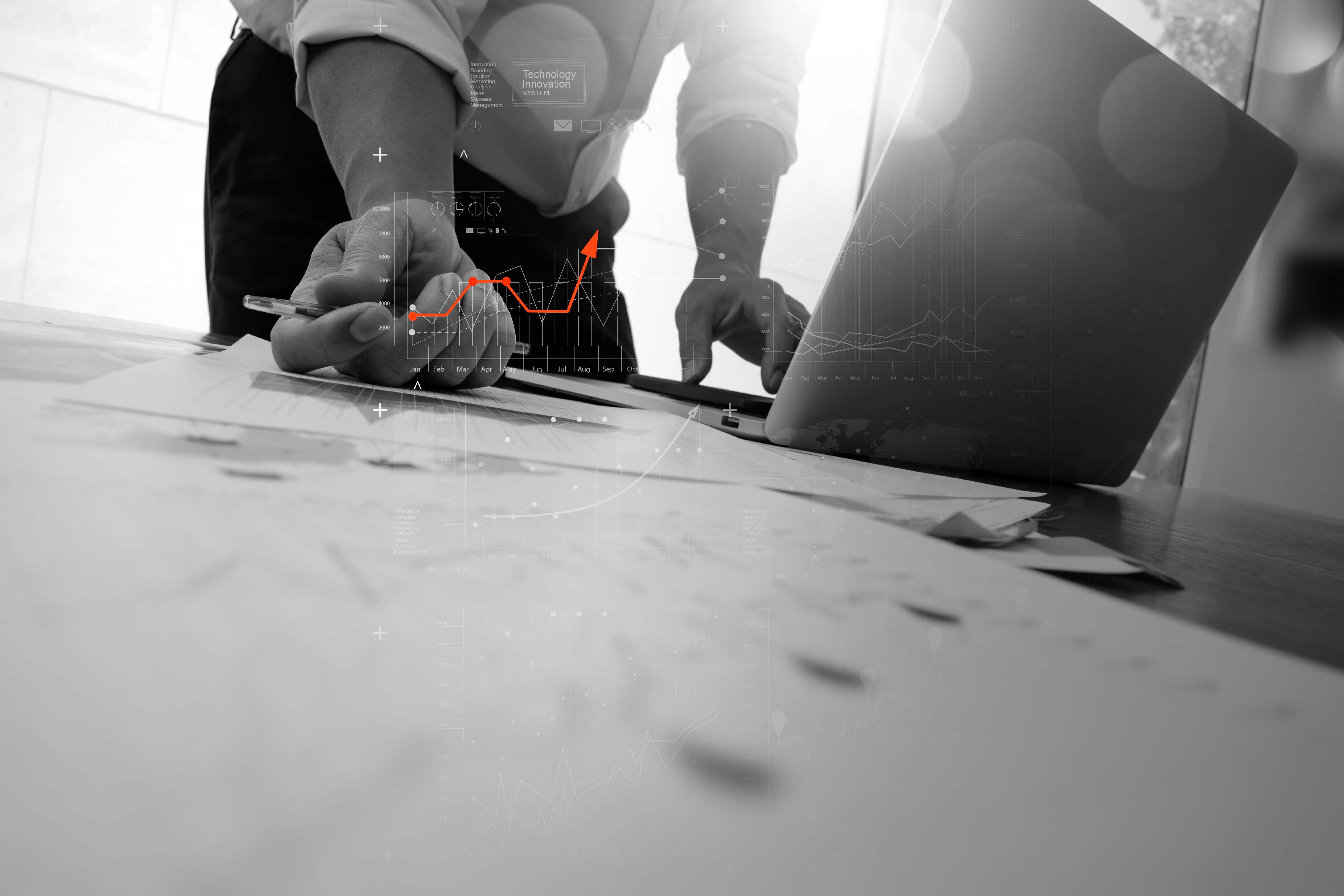 An image of someone (top of body out of shot) working at thier desk. There are graphics relating to performance superimposed onto the image. A neon orange upward trajectory arrow appears too. The image is aspirational.